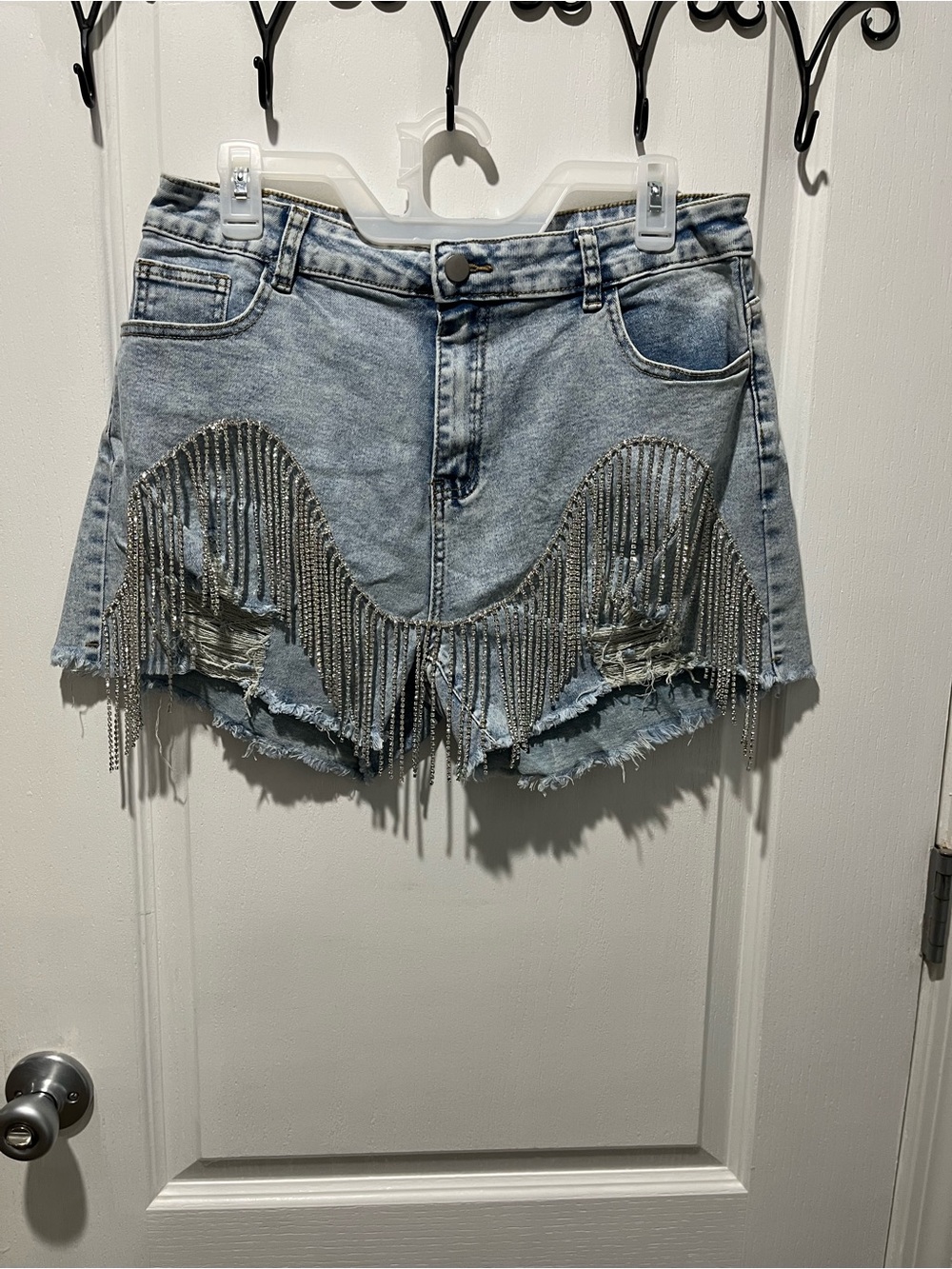 lite wash distressed denim shorts featuring rhinestone fringe